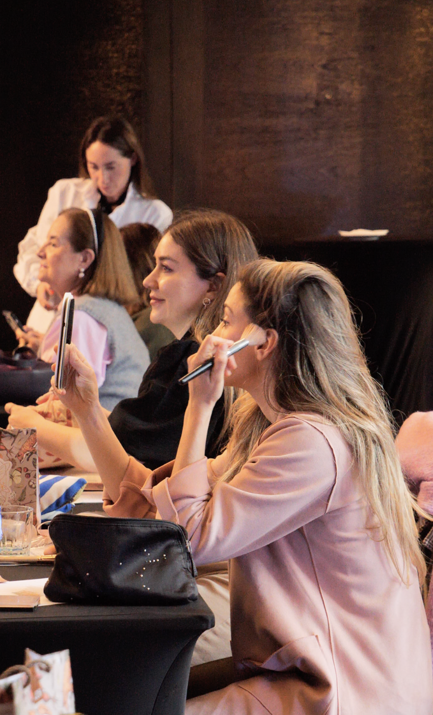 Asistentes practicando automaquillaje durante la clase